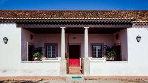 A building with a tiled roof, two columns, and a red carpet leading to the entrance. - Quinta da Gafaria (Almeirim)