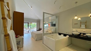 A modern hotel bathroom with a large bathtub, two sinks, and a balcony with a hammock. - Porto Pacuiba Hotel Ilhabela (Ilhabela)