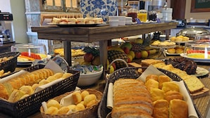 A buffet with various food items including bread, pastries, and fruits. - Porto Pacuiba Hotel Ilhabela (Ilhabela)