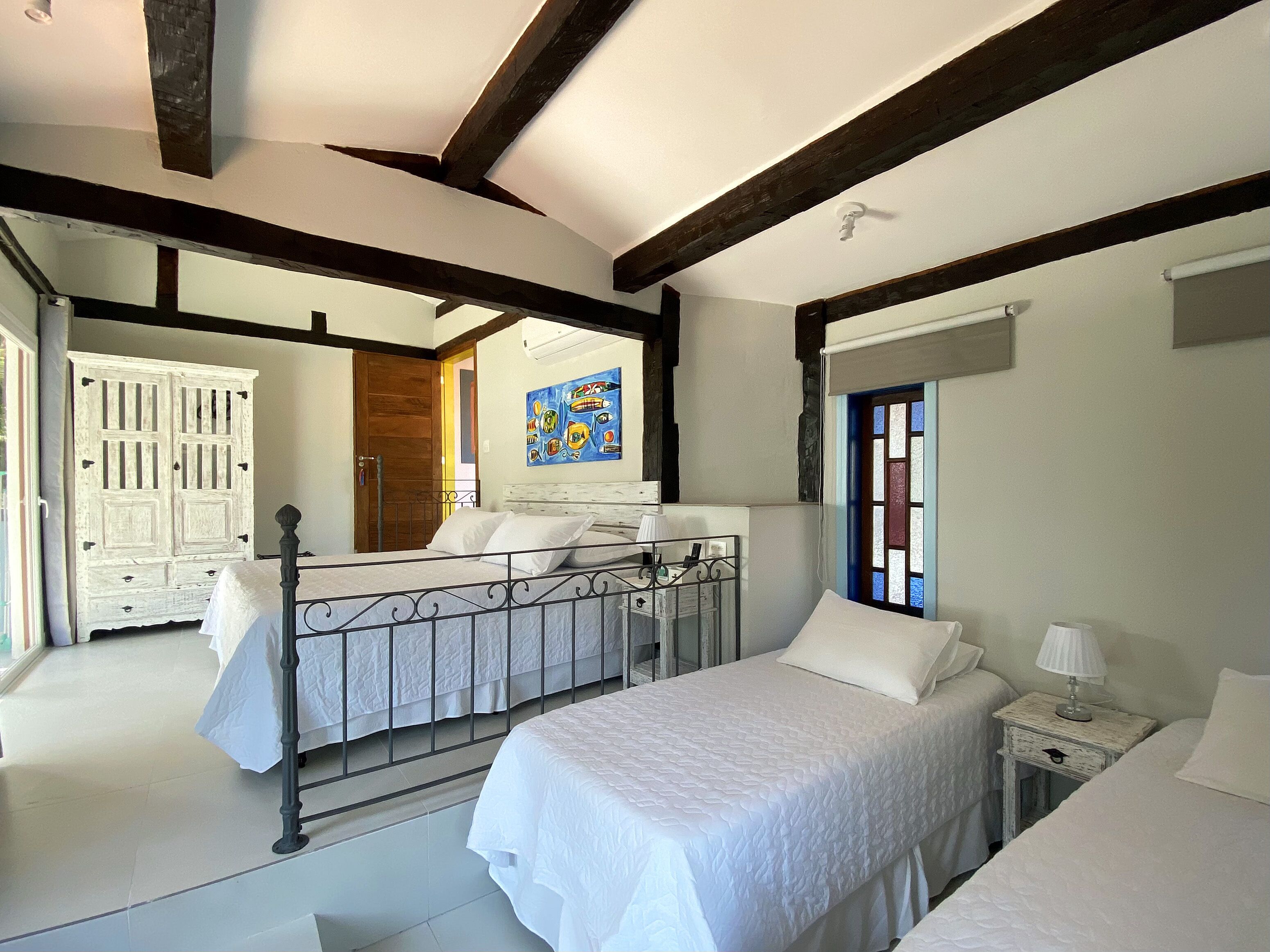 A bedroom with a bed, bedside tables, a wardrobe, and a window with a view.