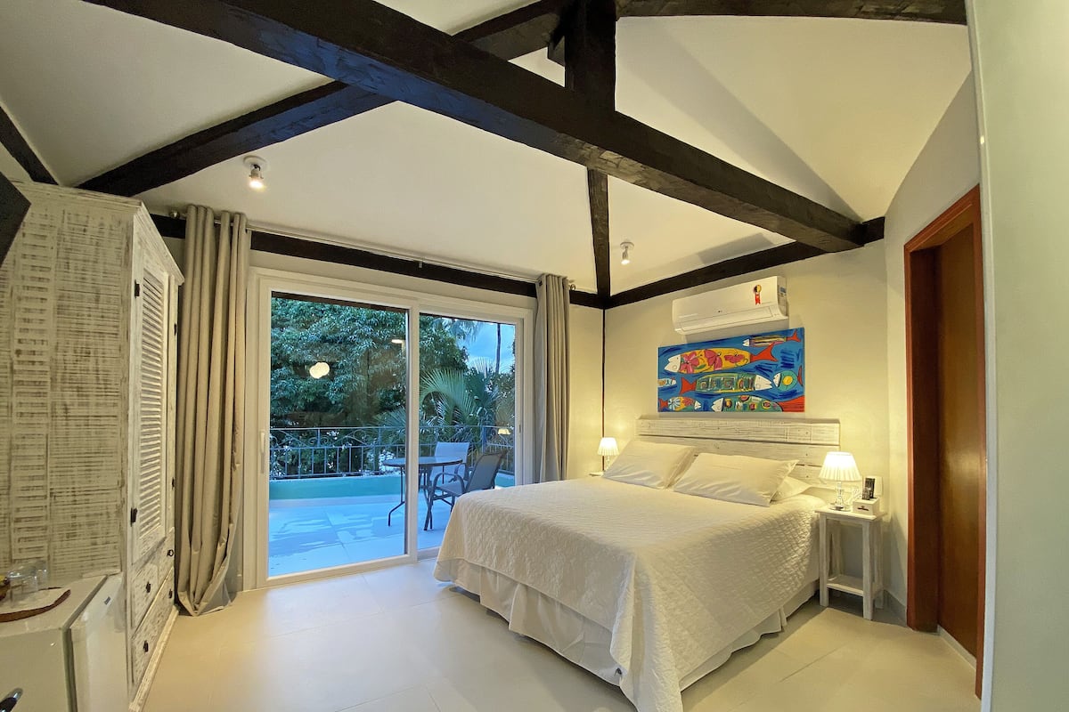 Une chambre à coucher avec un lit, une table de chevet, une fenêtre et une porte.