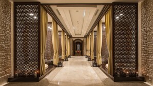 A corridor with a patterned wall, a tiled floor, and a ceiling with recessed lighting. - Rixos Borovoe (Burabay)