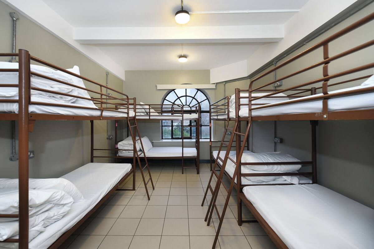A dormitory room with bunk beds, a skylight, and a view of the outdoors.