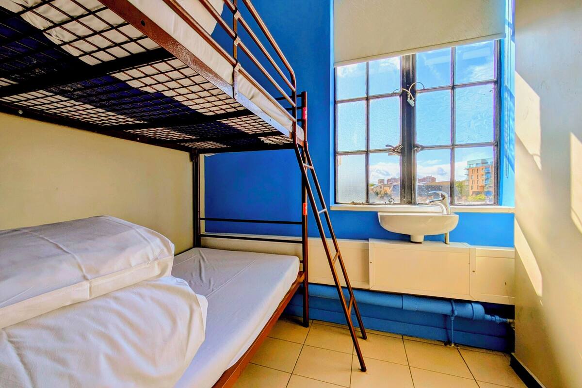 A bunk bed room with a window and a sink.