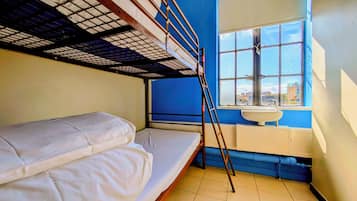 Dormitorio con literas, ventana y lavamanos.
