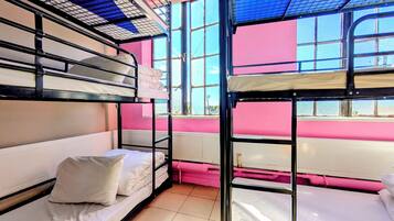 A bunk bed room with pink walls and a window.