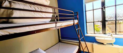 A bunk bed room with a window and a sink.
