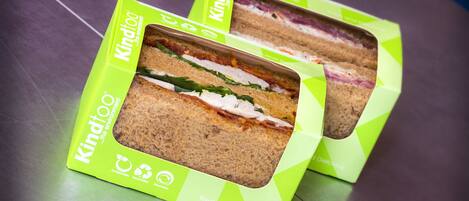 Two sandwiches in green packaging with visible fillings.
