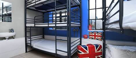 A bunk bed room with a sink and a suitcase with a Union Jack flag.