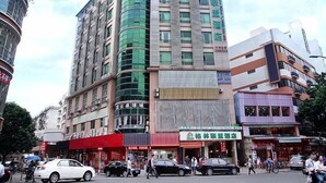 A multi-story hotel with a curved glass facade, multiple balconies, and a ground-level commercial area with signage. - GreenTree Alliance Shenzhen Shekou Sea World Hotel (Shenzhen)
