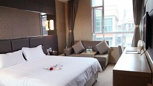 A hotel room with a large bed, a sofa, a desk, and a window with curtains. - GreenTree Alliance Shenzhen Shekou Sea World Hotel (Shenzhen)