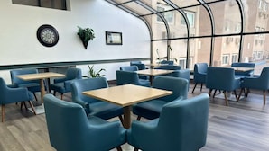 Un intérieur moderne avec des tables et des chaises, de grandes fenêtres et un plafond incurvé.
