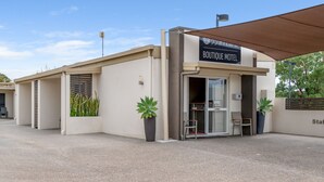A boutique motel with a modern design, featuring a signboard, a covered entrance, and potted plants. - 53 on Victoria (Warwick)