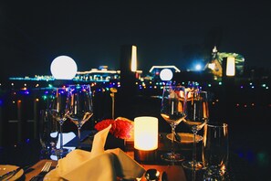 A table set for dining with wine glasses, a candle, and a flower arrangement.