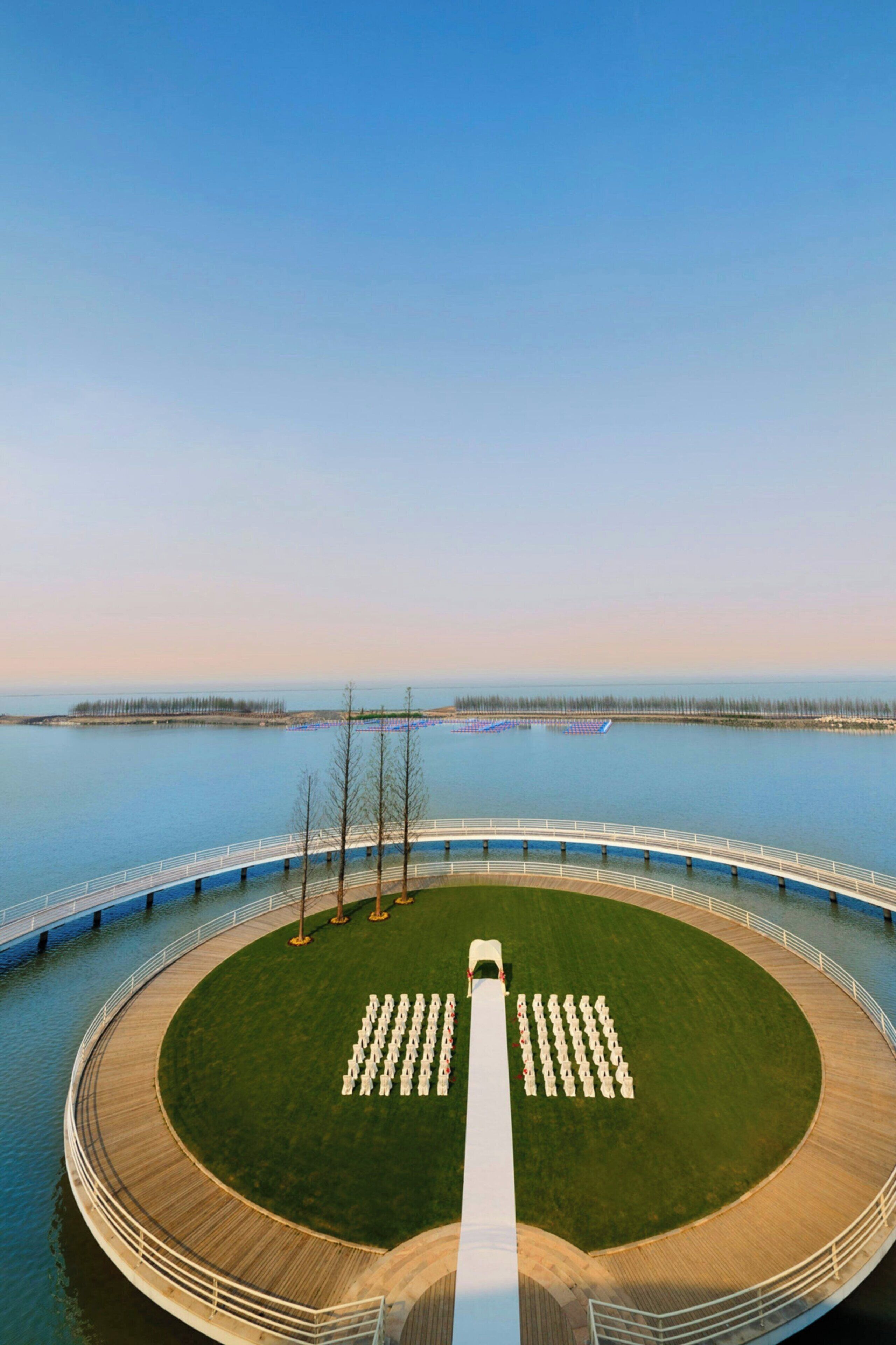 A circular outdoor area with a central pathway, surrounded by a wooden deck and a railing.