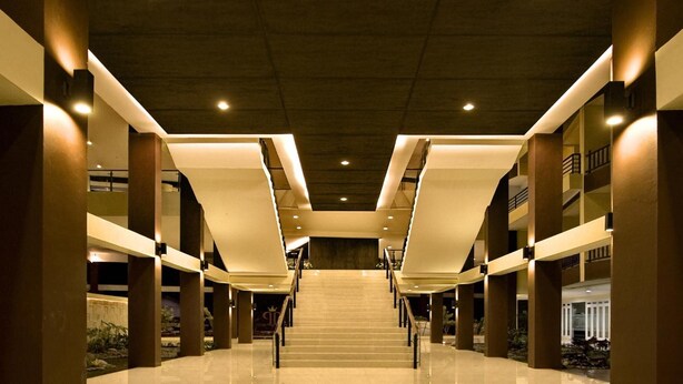 A spacious, modern interior with a central staircase, high ceilings, and a polished floor. - Palace Hotel (Cipanas)