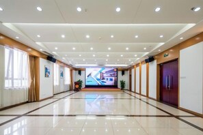 A hotel corridor with a polished floor, recessed lighting, and a large screen at the end. - China Electronics Huajing Business Hotel (Beijing)