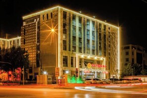 Un edificio de varios pisos con un letrero llamativo al nivel de la calle.