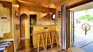 A wooden interior with a bar area, wooden stools, and a sign reading "La Cabane de Sam". - Le Domaine des Tuileries (Salins)