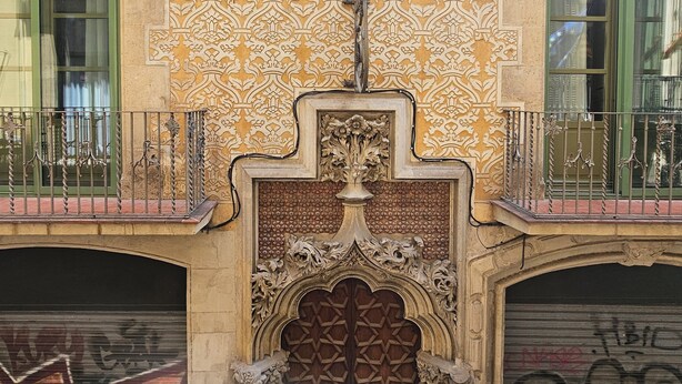 A building facade with ornate architectural details, including a decorative gate and a patterned wall. - Hotel Palermo Barcelona (Barcelona)