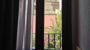 A room with a view of a traditional building through a window with curtains. - Hotel Palermo Barcelona (Barcelona)