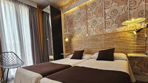 A hotel room with two beds, a modern chair, and patterned wallpaper. - Hotel Palermo Barcelona (Barcelona)
