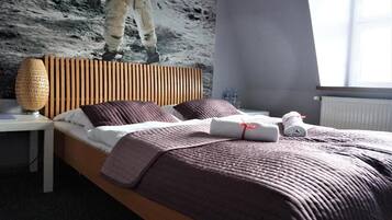 Una habitación de hotel con una cama, una mesita de noche y un mural en la pared.