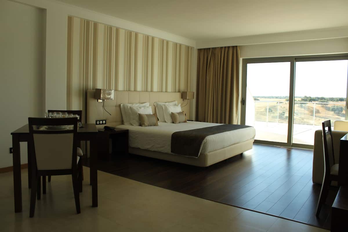 Een hotelkamer met een groot bed, een bureau en een stoel.