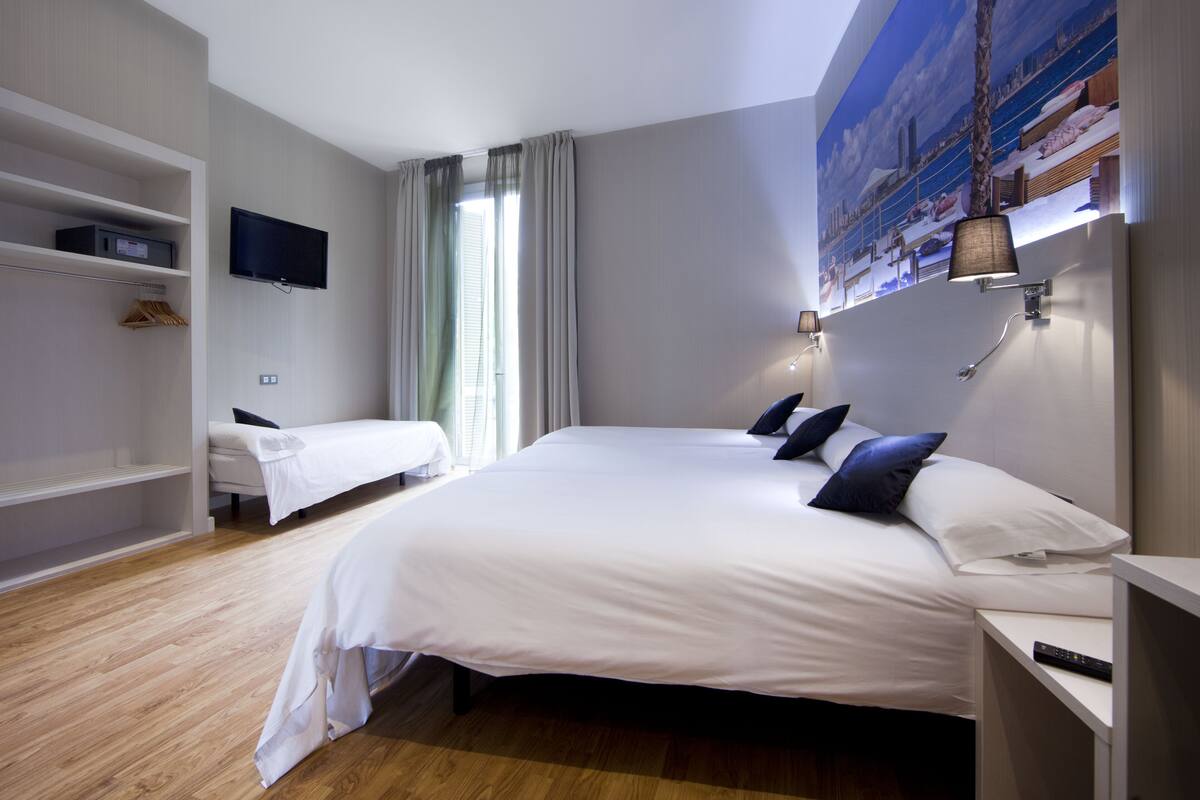 Habitación cuádruple, balcón | Caja fuerte, escritorio, cortinas opacas y sistema de insonorización