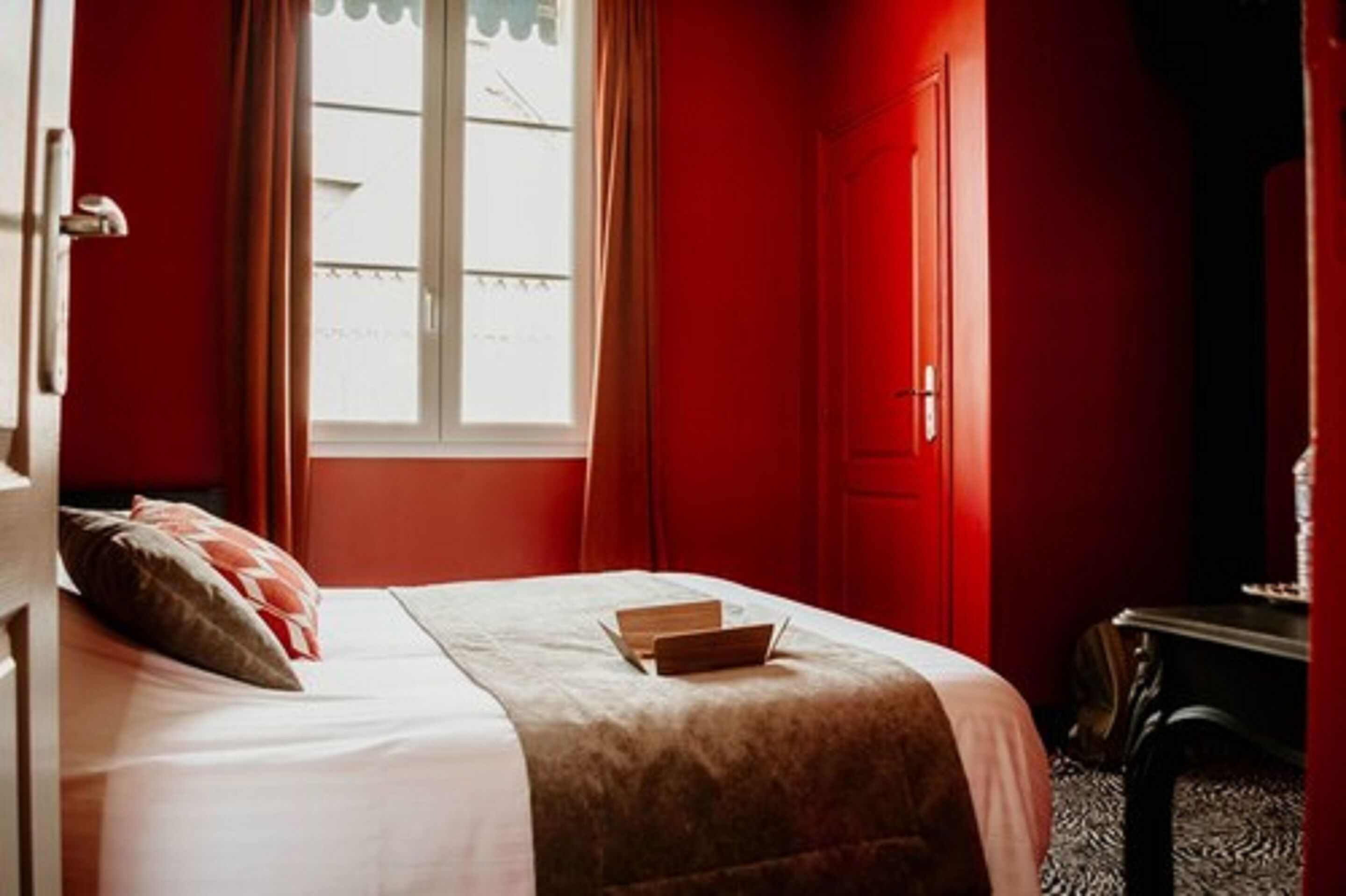 Een kamer met een bed, een raam en een deur.