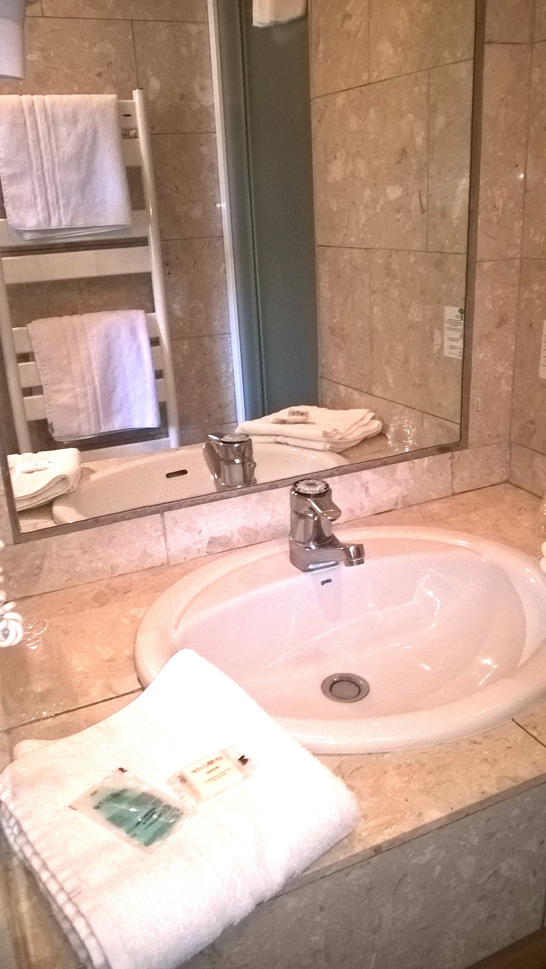 Ein Badezimmer mit Waschbecken, Spiegel und Handtuchhalter.