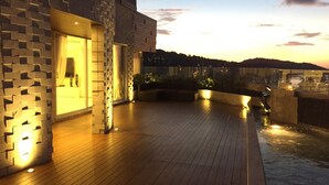 Un edificio moderno con terraza de madera y fuente de agua.