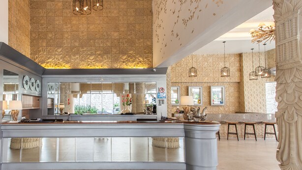 A spacious kitchen with a large island, pendant lighting, and a view of the dining area.