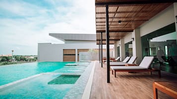 Un espace piscine moderne avec des chaises longues et une terrasse en bois.