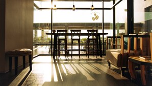 A modern interior with a dining area, a sofa, and a small table. - The Cavalli Casa Resort (Ayutthaya)