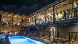 Ein zweistöckiges Gebäude mit Swimmingpool, Außenbereich und einem Balkon mit Geländern.