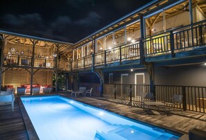 Una piscina al aire libre, sillones reclinables de piscina