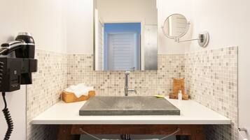 Une salle de bain avec un lavabo, un miroir et un porte-serviettes.