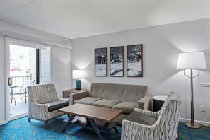 A living room with a sofa, two armchairs, a coffee table, and a lamp. There are three framed pictures on the wall. - WorldMark Wolf Creek (Eden)
