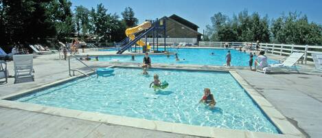 Une piscine avec un toboggan et un espace abrité.