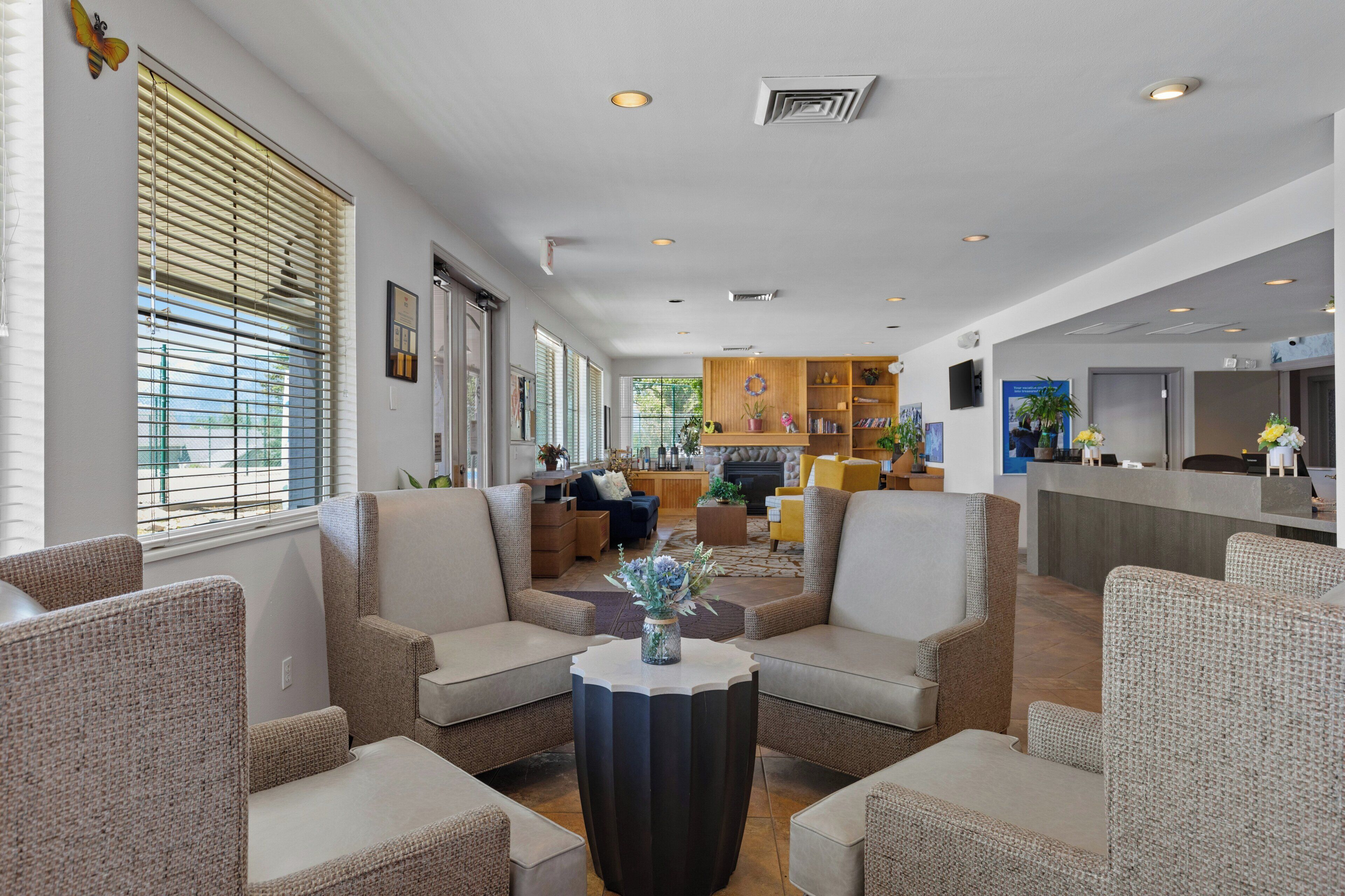 A spacious lobby with a reception desk, seating area with armchairs, and a fireplace.