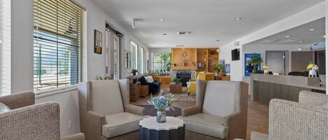 A spacious lobby with a reception desk, seating area with armchairs, and a fireplace.