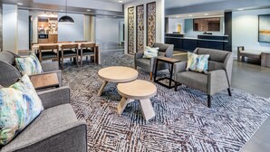 Un salon moderne avec des canapés gris, une table basse en bois et un tapis à motifs.