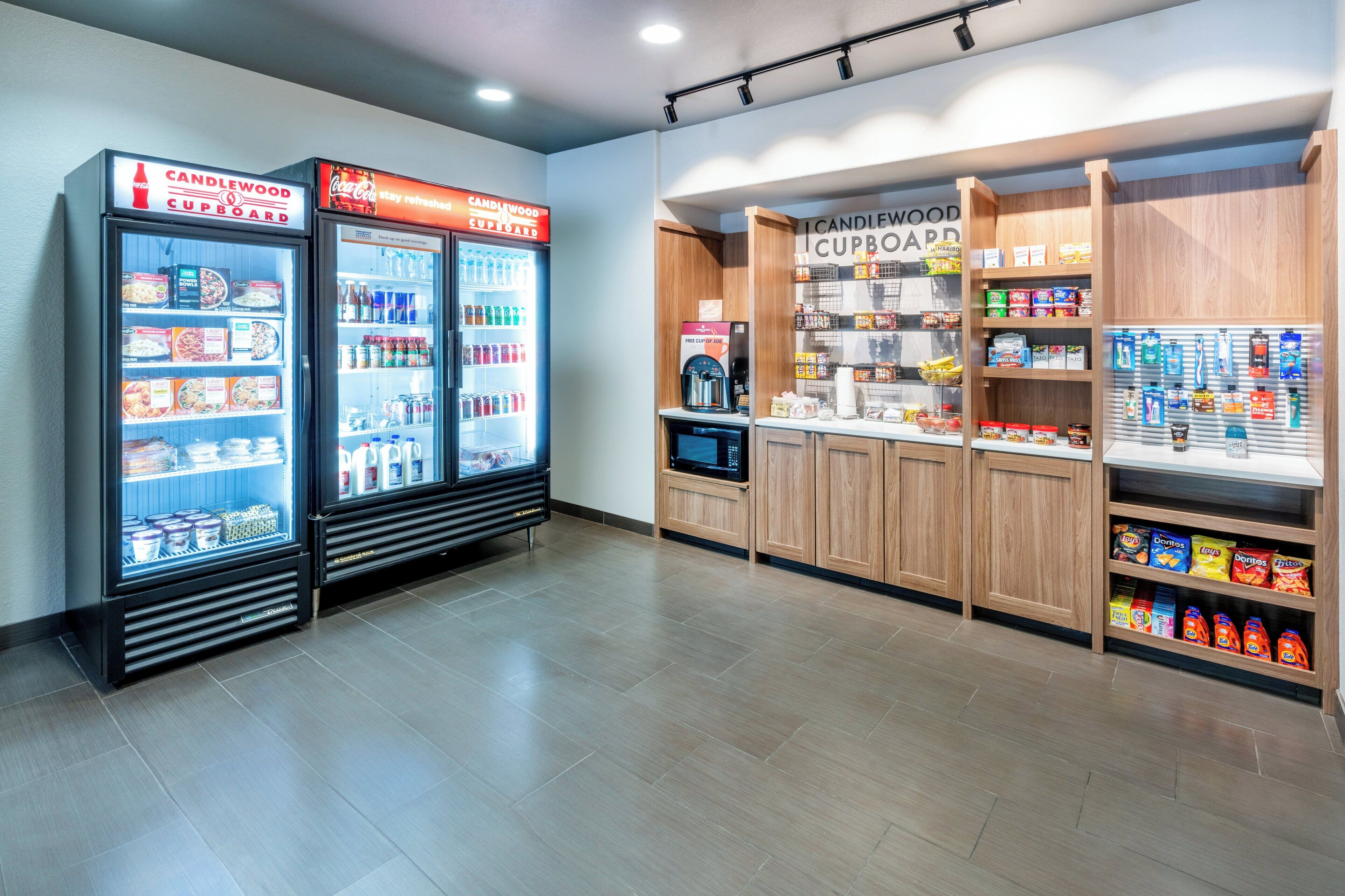 A Candlestead Cupboard with refrigerated food items and a microwave.