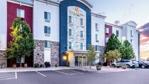 Un hotel con fachada moderna, que presenta una entrada destacada con puerta de vidrio y el letrero "Candlewood Suites".