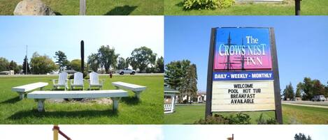 A park with picnic tables, a gazebo, a playground, and a sign directing to the Crow's Nest Inn.