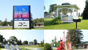 A hotel sign, a gazebo, picnic tables, a playground, and a swing set. - Crows Nest Inn Tawas (Tawas City)
