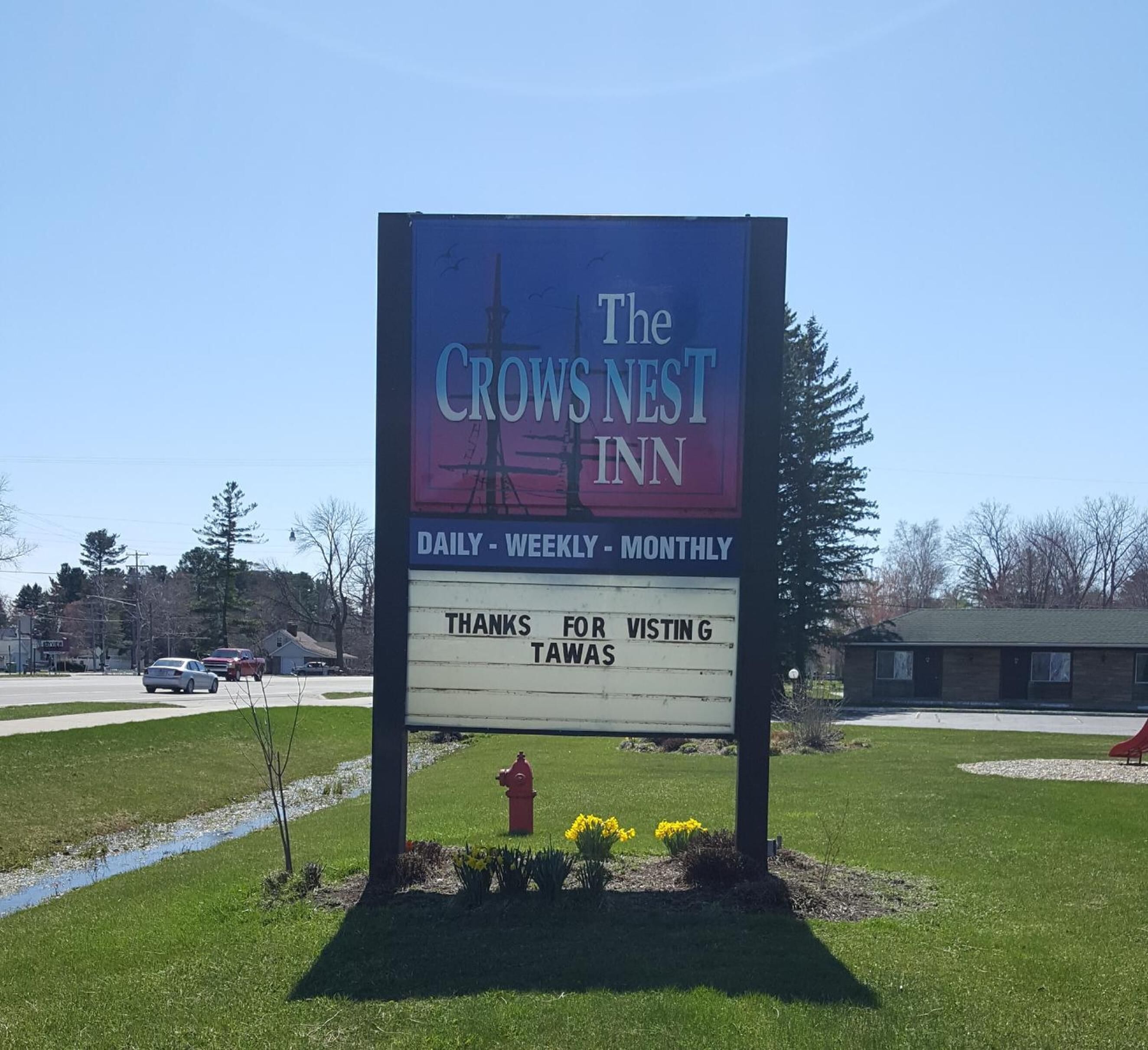 A sign for The Crows Nest Inn, indicating availability for daily, weekly, and monthly stays.