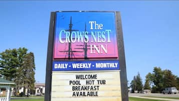 A sign for The Crows Nest Inn advertising daily, weekly, and monthly availability, pool, hot tub, and breakfast.
