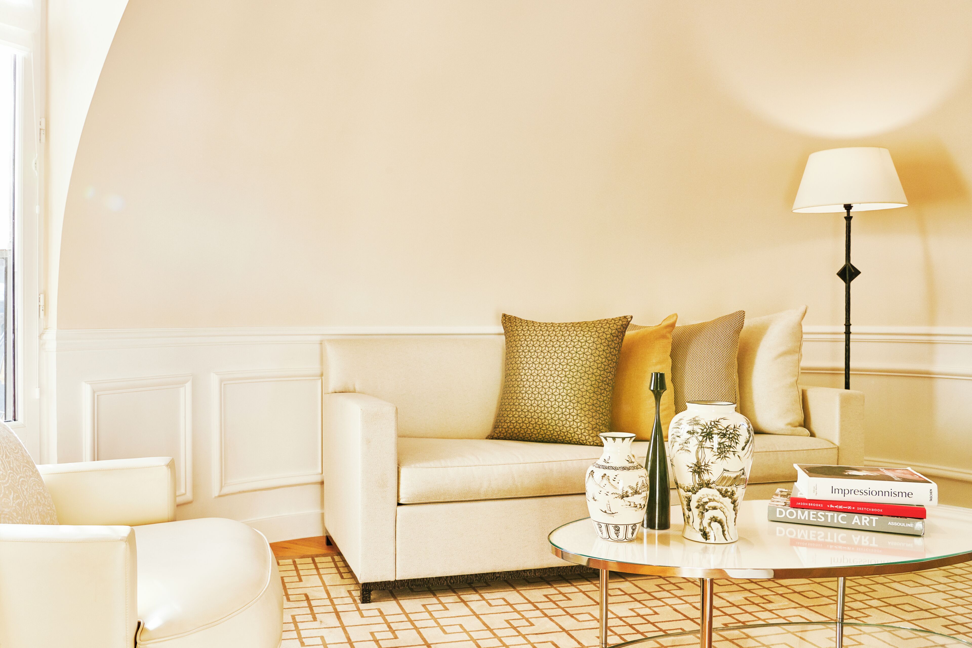 Ein Wohnzimmer mit einer Couch, einem Couchtisch, einer Lampe und Büchern.